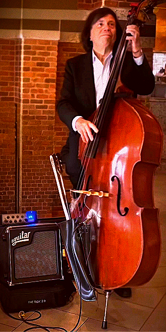 Phil Ravita playing upright bass beside an Aguilar amplifier